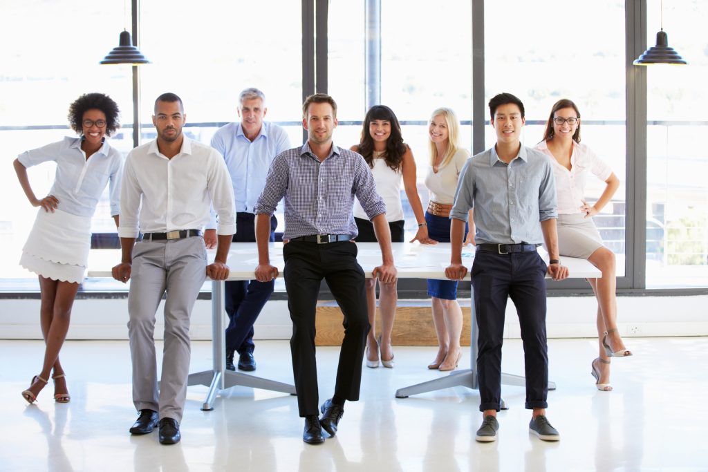 Coworkers posing to camera in meeting room